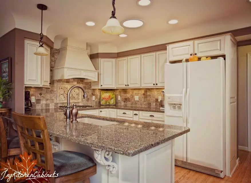 Beautiful kitchen cabinets that are white and cream colored.